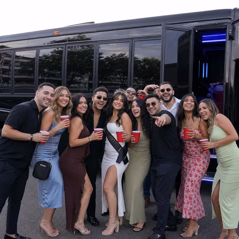 Group boarding a white charter bus for Birthday Transportation transportation in Milwaukee