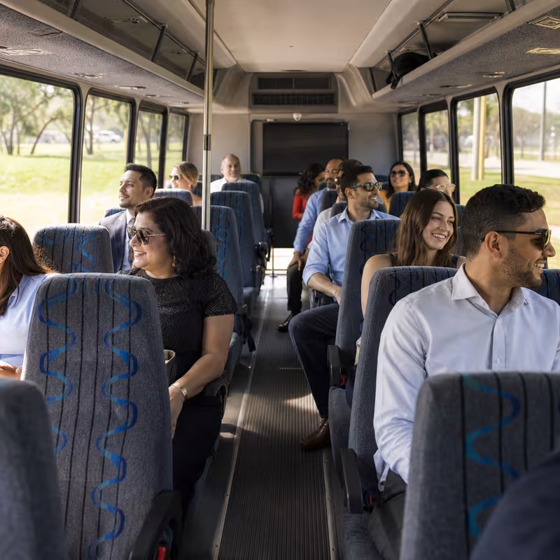 Group boarding a white charter bus for Private Event Transportation transportation in Milwaukee