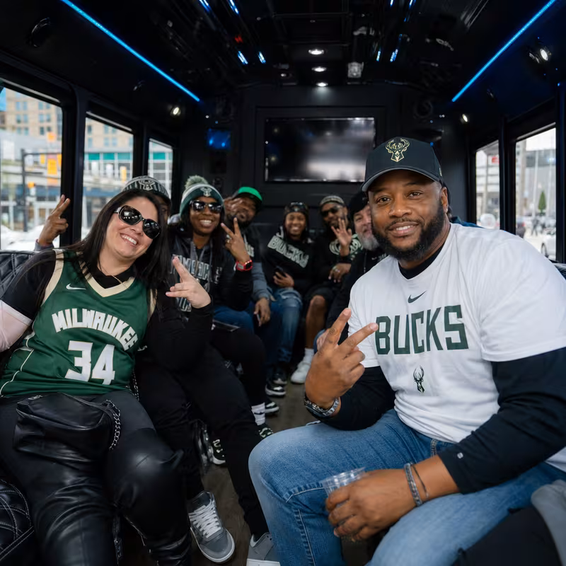 Group boarding a white charter bus for Sporting Event Transportation transportation in Milwaukee